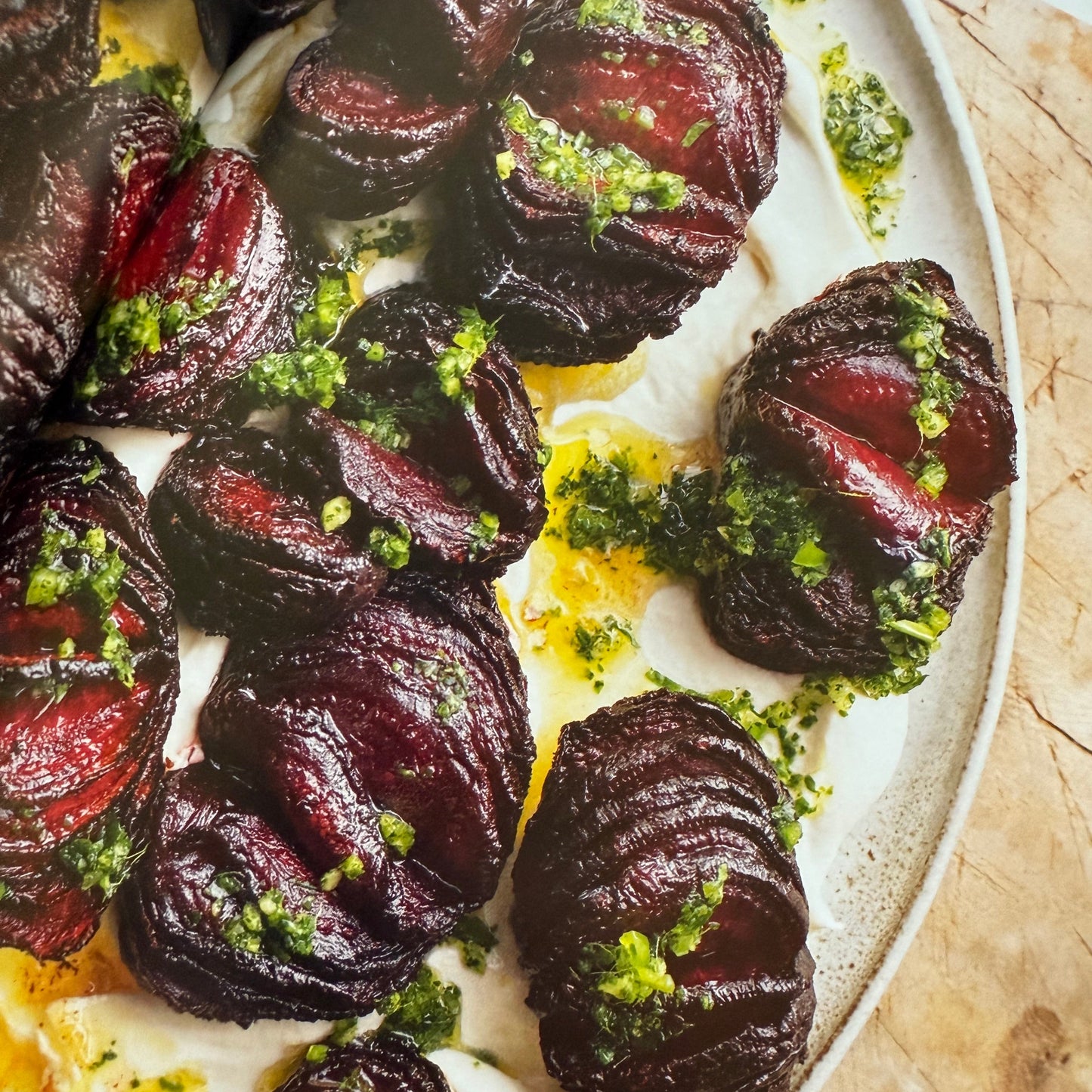 Roasted beets with green herb garnish on a white plate